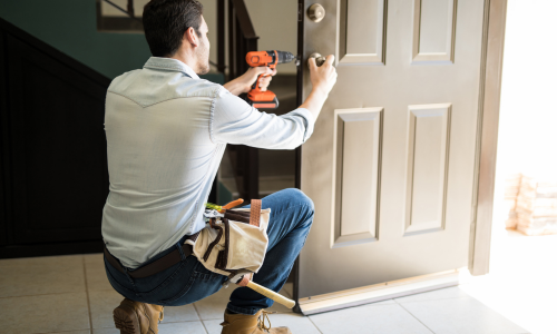 Contractor installing a door lock.